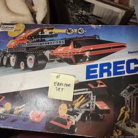 Box cover with artwork showing multiple models including a tracked vehicle and crane-like machinery built from metal beams and wheels.