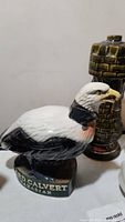 Ceramic eagle-shaped Lord Calvert Canadian Whiskey decanter, with detailed painting in white, black, and brown. The label is visible on the base.