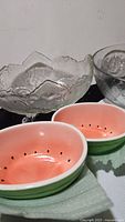 Four Albert Kessler & Co. watermelon ceramic bowls seen from inside and side showing pink interior and green rind exterior.