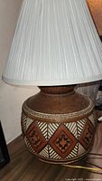 Photo showing the full base and pleated white lampshade of the southwestern style lamp.