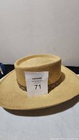 Genuine John B Stetson Panama Derringer cowboy straw hat showing flat crown and natural straw weaving with auction tag.
