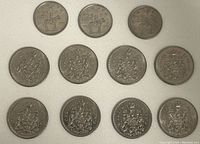Top view of 11 Canadian coins, 8 half dollars and 3 RCMP quarters all placed in rows on a white background.