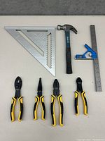 Overview of all seven hand tools including square, hammer, ruler, combination square, and four pliers.