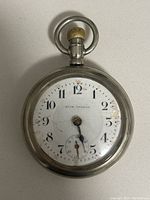 Front face of Seth Thomas pocket watch showing white dial, black numbers, and red minute markers.