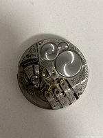 Close-up of Elgin watch movement showing gears, jewels, and engraved parts