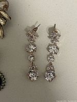 Close-up of long drop clear stone earrings