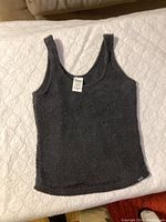 Black cozy sleeveless tank top laid flat, showing texture and overall condition.