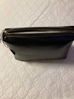 Top view showing black leather exterior with zipper closure on pouch.