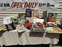 Overview of the full lot showing multiple games, posters, fabric panels, decorative items, and framed art arranged on a table