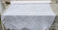 Photo showing full bolt of white cotton drapery fabric with measurement 4 feet 6 inches across table