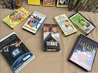 Close view of select VHS tapes including Fantasia, E.T., Titanic, Winnie the Pooh, and others arranged on display surface