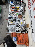 Full spread of tools and accessories on a flat surface with gloves and casters visible.