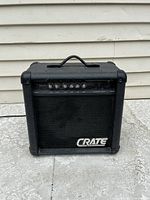 Front view of a black Crate GX-15 guitar amplifier showing control knobs, speaker grille, and brand logo.