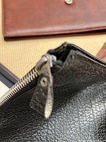 Close-up of zipper and leather texture on black pouch
