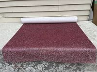 Full photo of the rolled wallpaper showing bright pink sparkles and the roll length.