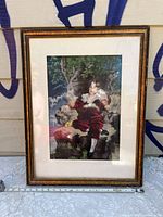 Front view of vintage framed needlepoint artwork showing a Regency style seated man in outdoor scenery.