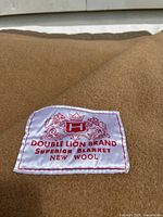 Close-up of Double Lion Brand label showing superior new wool quality and logo with two lions and crown.