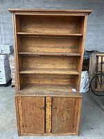 Front view showing three open shelves above two-door cabinet base