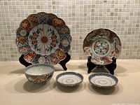 Front view of all five pieces: 8 inch plate, bowl, and three small dishes with ceramic stands