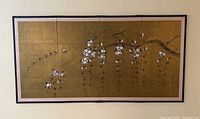 Full view of the four-panel folding screen mounted on a wall showing cherry blossom branch design on gold background.