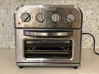 Front view of the stainless steel Cuisinart toaster oven and air fryer showing control dials and door.