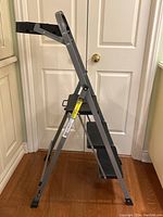 Side view of the lightweight metal three step ladder showing frame, steps, and paint tray.