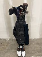 Overview of the full golf set including golf cart bag with clubs and shoes in front