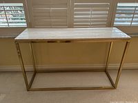 Front view showing full table with travertine top and brass frame