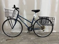 Side profile of blue Specialized Crossroads 18-speed bike with front and rear baskets
