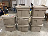 Eight beige plastic storage bins stacked in two columns of four, showing all bins and lids with dimensions visible in surrounding area.