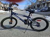 Side view showing the full blue Mongoose Phantom BMX bike with tires, frame, seat, and handlebars visible under daylight outdoors.