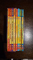 Spine view showing titles and volume numbers of the eight Geronimo Stilton books, all in pristine condition and vivid colors.