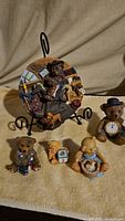 Photo of all teddy bear figurines and collectible plate on a fabric surface