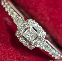 Front/top view showing princess-cut center diamond and surrounding halo of round diamonds