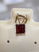 Front view of the square-cut garnet pendant in 10 karat gold