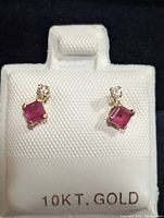 Front view of the 10K gold earrings with square-cut ruby and diamond.