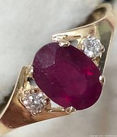 Front view of ring showing oval ruby and side diamonds
