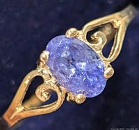 Close-up front view of oval tanzanite in four-prong setting revealing cut and color