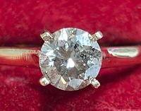 Front view of solitaire diamond on band against red background