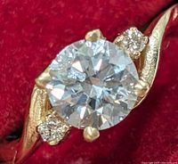 Top view of ring showing round center diamond and two side diamonds on twisted gold shank