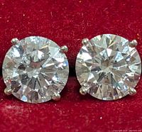 Front view of both round brilliant lab diamond studs on red background