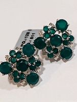 Front view of the pair of silver earrings with green onyx stones arranged in a floral cluster pattern.
