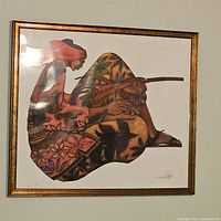 Framed print of stylized musician playing a stringed instrument hung on wall