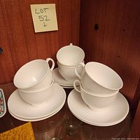Six white Wedgwood Galaxie cups stacked with matching saucers.