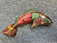 Top view of multicolored carved wooden fish sculpture showing painted red, green, and brown details.