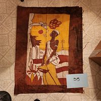 Full view of the cloth showing the entire design of African woman and plants, with seller lot number card.