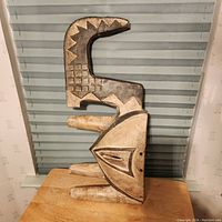 Front and side views of the solid wood African tribal mask showing geometric carvings and wear.