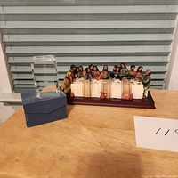 Photo showing full lot on tabletop including ceramic Last Supper figurine and crystal etched block on blue box against window blinds background.