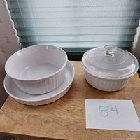 Three white baking dishes shown together; two are nesting, one with glass lid visible