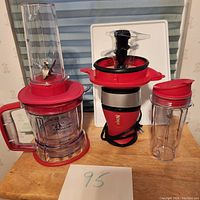 Full view of Ninja Pulse blender with attachments including pitcher, blending cup with lid, and smaller container on wood surface.